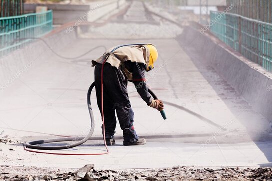 Mitarbeiter mit Schutzausrüstung beim Trockeneisstrahlen